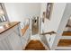 Wooden staircase with white trim, leading to a bright hallway featuring artwork, offering a warm, inviting atmosphere at 6664 Windwood Cir, Douglasville, GA 30135