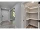 Hallway view with wood-look floors and a walk-in storage pantry with white shelves at 2381 Highpoint Rd, Snellville, GA 30078