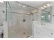 Luxury walk-in shower with rain head and seat, alongside a vanity with farmhouse sink and decorative mirror at 343 Woodstone Dr, Marietta, GA 30068