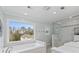 Bright bathroom featuring a soaking tub with a view and a glass enclosed shower with marble-style tiling at 343 Woodstone Dr, Marietta, GA 30068