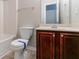 Bathroom with cherry-stained cabinets and a toilet with a blue paper strip at 610 Maltese Dr, Atlanta, GA 30349