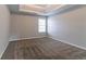 This carpeted bedroom features a tray ceiling, a bright window, and neutral paint at 610 Maltese Dr, Atlanta, GA 30349