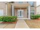 A welcoming front porch of a brick home with a decorative door and manicured bushes at 610 Maltese Dr, Atlanta, GA 30349