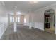 Spacious living room features neutral decor, carpet, and arched entrance to kitchen at 610 Maltese Dr, Atlanta, GA 30349