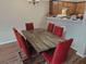 Dining room featuring a wooden table, six red chairs, and wood-look laminate floors at 100 Chandler Trce, Covington, GA 30016