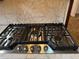 Close-up of a stainless steel cooktop with multiple burners and sleek controls, set against a marble backsplash at 1046 Sans Souci Way, Clarkston, GA 30021