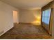 Open living room with neutral walls, carpeted floors, and a window view at 1046 Sans Souci Way, Clarkston, GA 30021