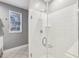 Bathroom featuring a glass shower, white tiles, and a window with natural light at 4203 Stratford Commons # 4203, Decatur, GA 30033