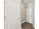 Bright hallway featuring hardwood floors, white trim, and a paneled door at the end at 4203 Stratford Commons # 4203, Decatur, GA 30033