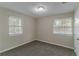 Bright bedroom with neutral walls, plush carpet, and natural light from two windows at 645 Plainville Sw Dr, Atlanta, GA 30331