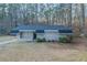 Ranch-style home features a brick facade, dark roof and door, trimmed bushes, and a lush, wooded landscape at 645 Plainville Sw Dr, Atlanta, GA 30331