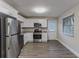 Charming kitchen features stainless steel appliances, white cabinets, granite counters, and wood-look flooring at 645 Plainville Sw Dr, Atlanta, GA 30331
