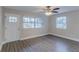 Bright living room boasts wood-look flooring, two windows, a white entry door, and a ceiling fan at 645 Plainville Sw Dr, Atlanta, GA 30331
