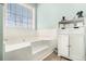 Bathroom featuring a large soaking tub, cabinets, and window for natural light at 1176 Whatley Mill Ln, Lawrenceville, GA 30045