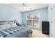 A cozy bedroom featuring blue walls, a large window for natural light, and a comfortable bed with a blue and white comforter at 1176 Whatley Mill Ln, Lawrenceville, GA 30045