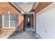 Close-up of a home's brick facade, front door, and attached garage entrance at 1176 Whatley Mill Ln, Lawrenceville, GA 30045