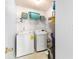 A functional laundry area with a washer, dryer, and storage shelves at 1176 Whatley Mill Ln, Lawrenceville, GA 30045