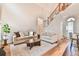 Sunlit living room with staircase and hardwood floors, creating a bright and airy space at 2685 Lenora Church Rd, Snellville, GA 30078