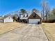 Brick-facade house featuring dormer windows, a two-car garage, and a large driveway at 310 Creekside Trl, Covington, GA 30016