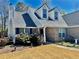 Charming brick home featuring dormer windows, a chimney, and landscaped front yard at 310 Creekside Trl, Covington, GA 30016