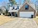 Two-story brick home with a well-manicured lawn, dormer windows, and a two-car garage at 310 Creekside Trl, Covington, GA 30016