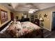 Main bedroom with patterned bedding, a ceiling fan, and dark hardwood floors at 310 Creekside Trl, Covington, GA 30016