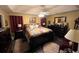 Main bedroom with patterned bedding, a ceiling fan, and dark hardwood floors at 310 Creekside Trl, Covington, GA 30016