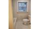 Bathroom with white tiled floor and walls, a toilet, and a window with blinds at 3112 Cloverhurst Dr, Atlanta, GA 30344