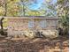 Exterior shot of the back of the home showcasing a brick facade, mature trees, and a deck at 1692 Shirley Sw St, Atlanta, GA 30310