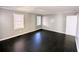 This bedroom features black hardwood floors, neutral gray walls, and bright natural light from two windows at 1692 Shirley Sw St, Atlanta, GA 30310