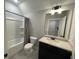 Well-lit bathroom featuring a tub with shower and vanity with marble countertop at 222 Blossom Trl, Acworth, GA 30101