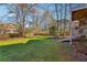 Expansive backyard featuring mature trees and a wooden fence next to a home's elevated deck at 2541 Deer Isle Cv, Lawrenceville, GA 30044