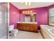 Purple bathroom featuring a vanity with a sink, toilet, shower, and tub at 2541 Deer Isle Cv, Lawrenceville, GA 30044