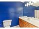 Blue bathroom featuring a vanity with a sink, mirror, and toilet at 2541 Deer Isle Cv, Lawrenceville, GA 30044