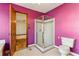 Purple bathroom featuring a glass shower, toilet, and entry to another room at 2541 Deer Isle Cv, Lawrenceville, GA 30044