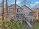 Back of home featuring a multi-level deck, stairs to the backyard, and wooden facade at 2541 Deer Isle Cv, Lawrenceville, GA 30044