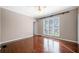 Bedroom featuring hardwood floors, white molding, and large window overlooking the yard at 3167 Bay View Dr, Jonesboro, GA 30236