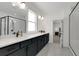 Luxurious bathroom featuring a white vanity with granite countertops, sleek fixtures, and marble-look tile at 335 Tillman Pass, Woodstock, GA 30188