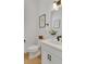 Clean powder room with a white vanity, modern faucet, and framed botanical prints at 335 Tillman Pass, Woodstock, GA 30188