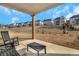 View of the covered patio with chairs and small table overlooking the backyard and other homes at 335 Tillman Pass, Woodstock, GA 30188