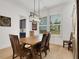 Well-lit dining room with wood table and chairs, complemented by a modern chandelier and large window at 335 Tillman Pass, Woodstock, GA 30188