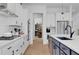 White kitchen with stainless steel appliances, a navy island and hardwood floors at 335 Tillman Pass, Woodstock, GA 30188