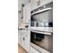 Kitchen with stainless steel oven, white cabinets with black handles and view to living room at 335 Tillman Pass, Woodstock, GA 30188