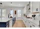 Bright kitchen featuring white cabinets, quartz countertops, and an island with a black faucet and navy blue cabinets at 335 Tillman Pass, Woodstock, GA 30188