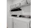 Practical laundry room with front-load washer and dryer, plus overhead wire rack and baskets at 335 Tillman Pass, Woodstock, GA 30188