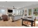 Open-concept living room with light hardwood floors, large windows, and a fireplace with a brick surround at 335 Tillman Pass, Woodstock, GA 30188