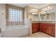 This primary bathroom features a garden tub, double sinks, and large vanity mirrors at 8885 Camp Tree Ct, Winston, GA 30187