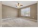 Neutral walls, a ceiling fan and large window highlight this cozy carpeted bedroom at 8885 Camp Tree Ct, Winston, GA 30187