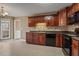 Well-lit kitchen featuring tile floors, wood cabinets, and black appliances at 8885 Camp Tree Ct, Winston, GA 30187