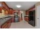 This eat-in kitchen features dark wood cabinetry and black appliances at 8885 Camp Tree Ct, Winston, GA 30187